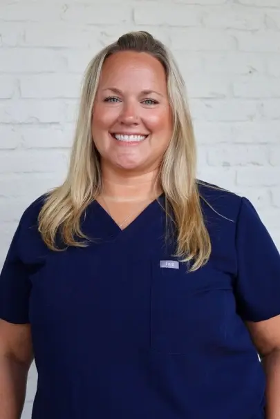 Rebekah, dental team member at Baton Rouge practice, smiling in navy scrubs.